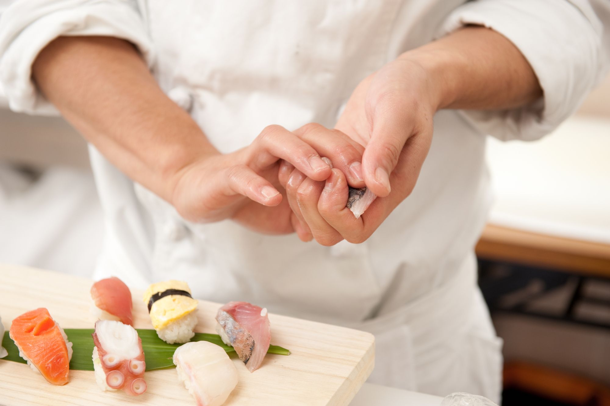 Portrait of head chef Yuichi Maetomo behind the sushi counter