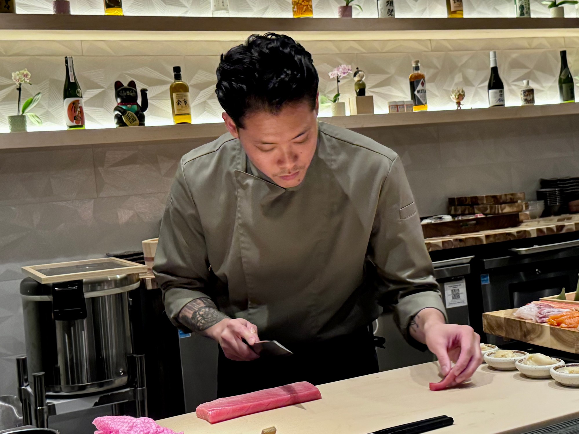 Portrait of sous chef Lewis Compton plating a dish